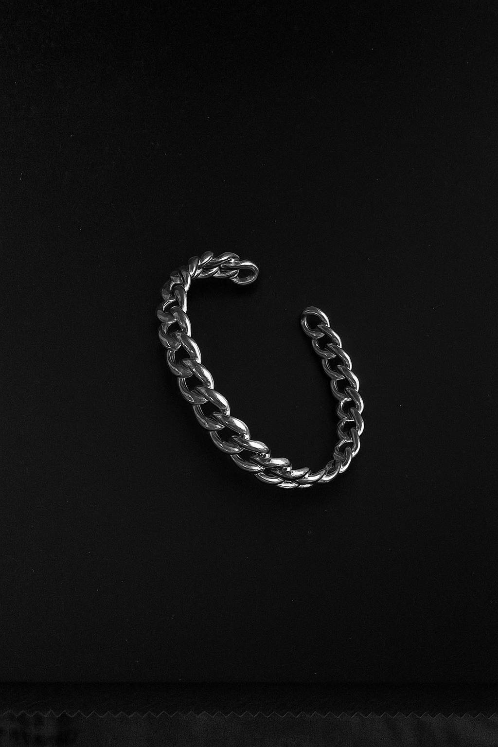 Silver chain bracelet on a black background