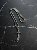 Silver necklace with a unique pendant on a dark marble surface