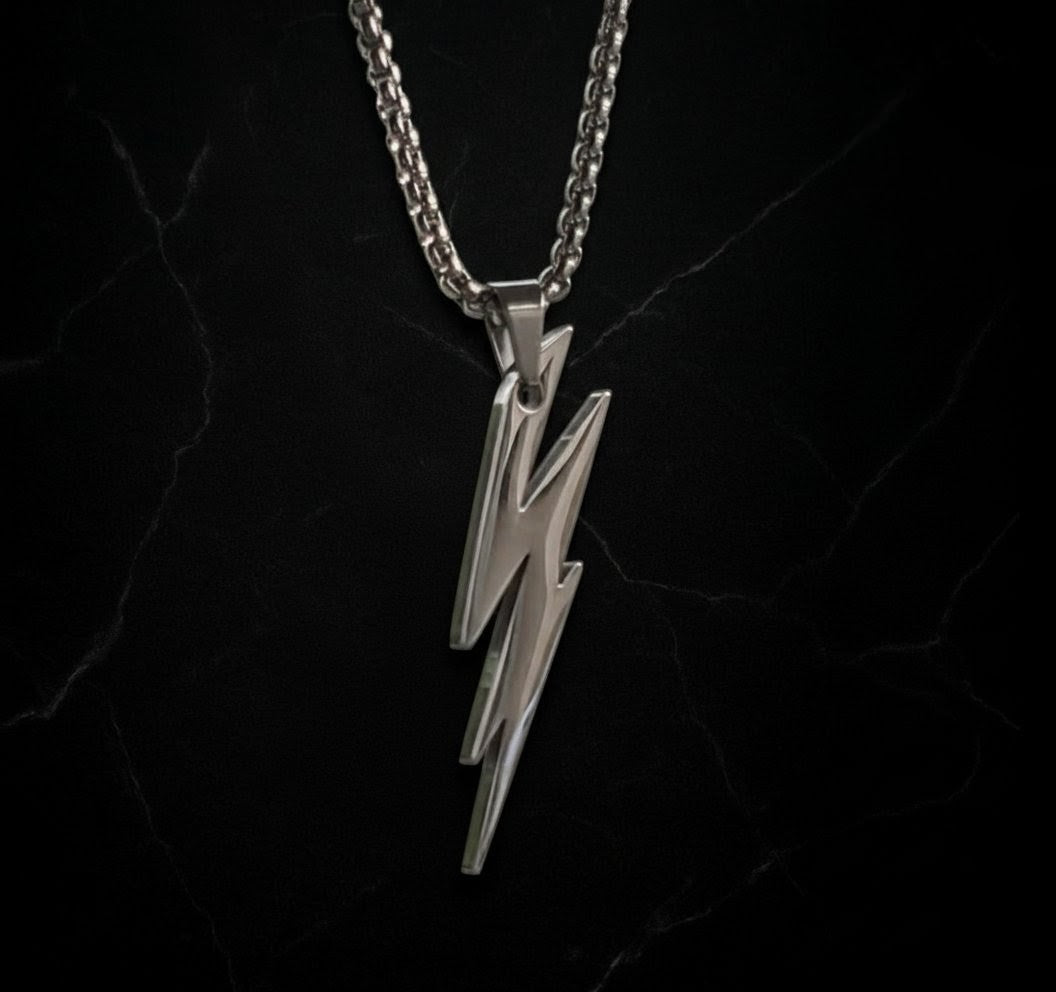 Silver lightning bolt pendant on a black chain against a black background